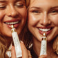 Two women holding LAVLOE lip products close to their faces.